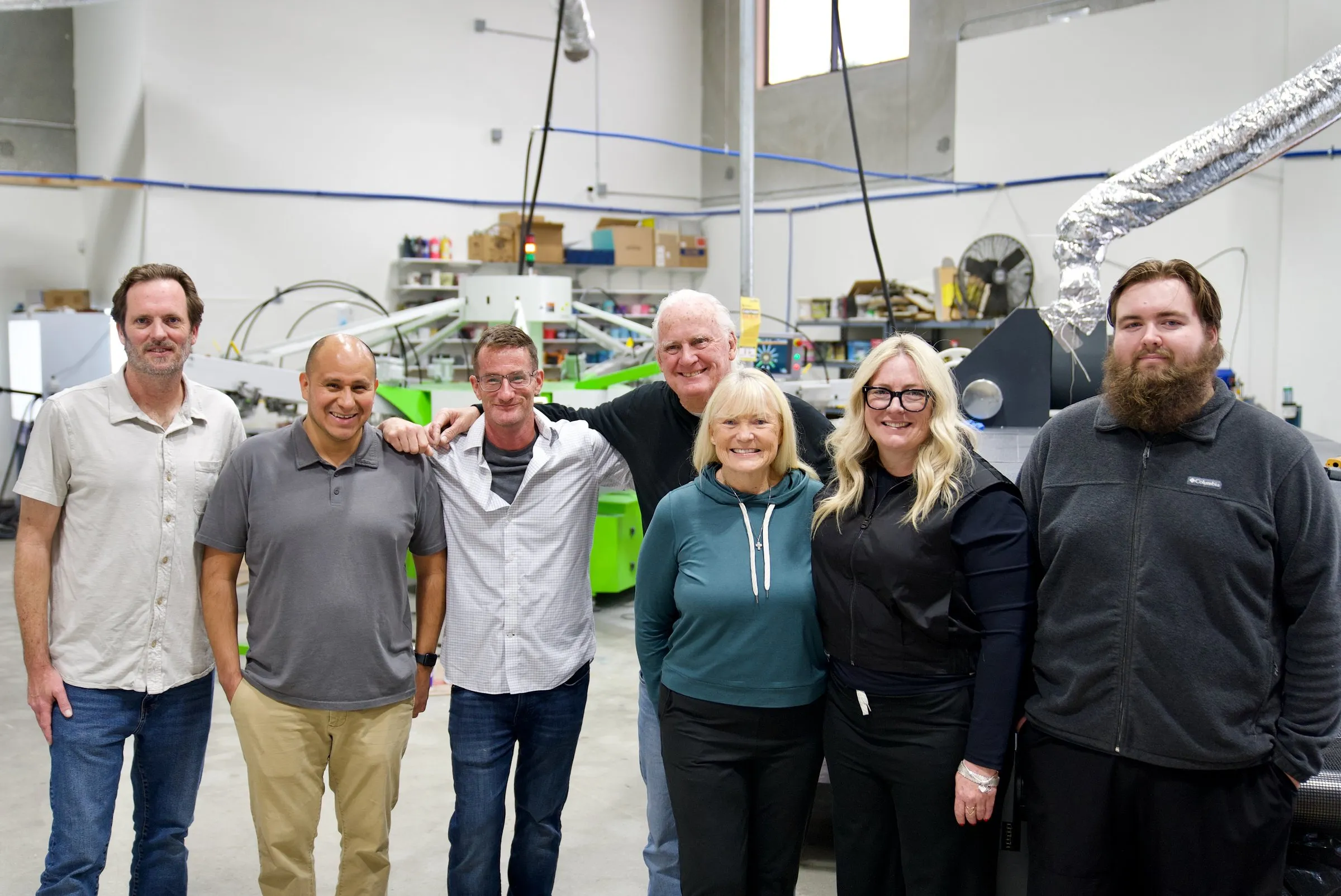 The Lamb Screen Printing crew in front of an automatic press at the San Marcos shop.