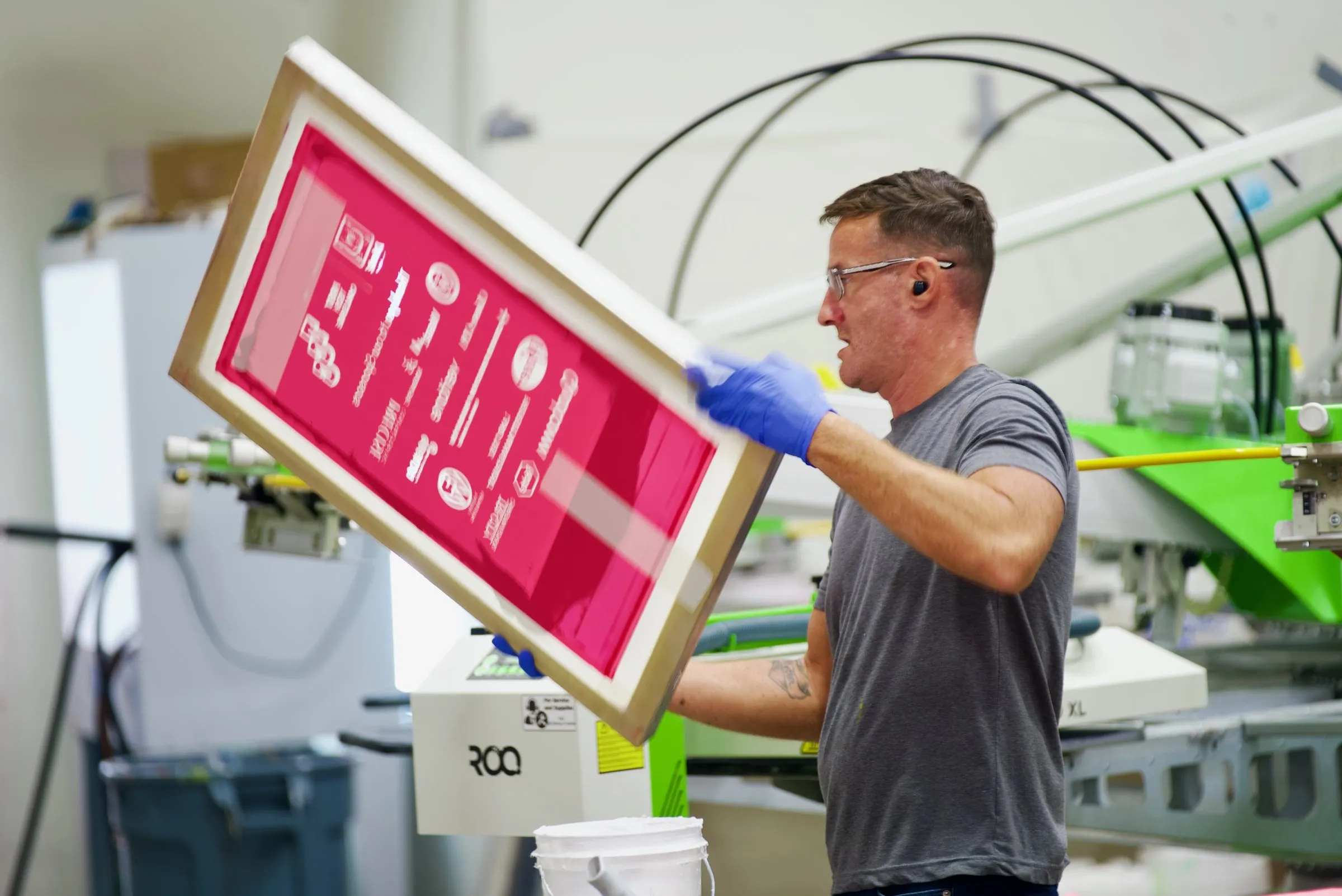 A printer checking a screen at the press