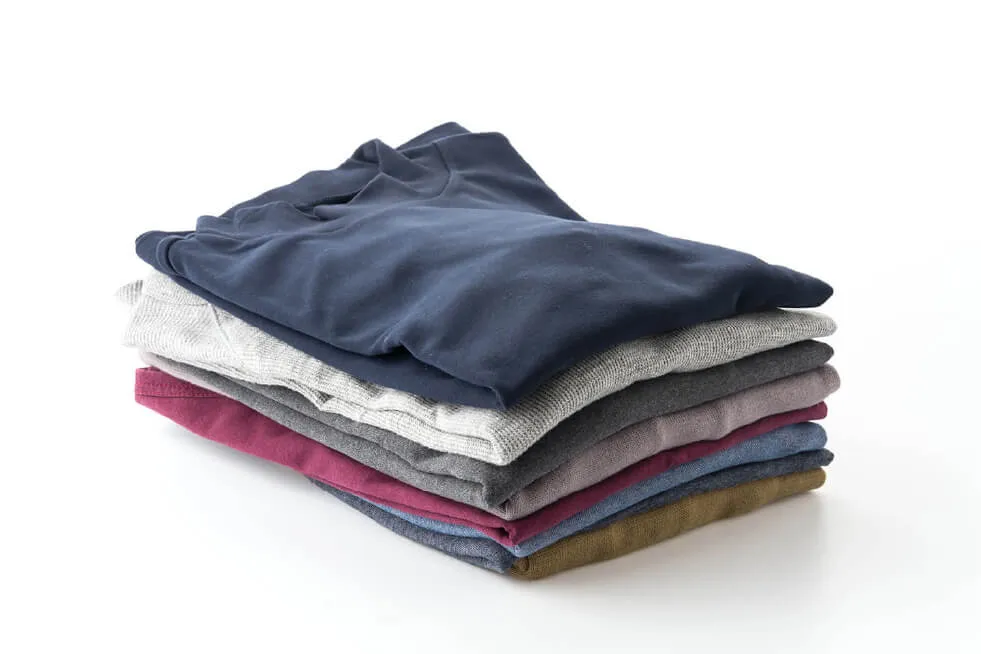A stack of neatly folded t-shirts in various colors on a white background.